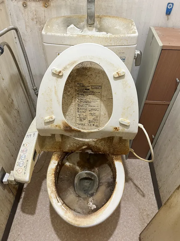 施工前：便器と便座に尿石と汚れが固着したトイレ